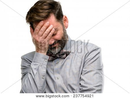 Middle age man, with beard and bow tie stressful keeping hands on head, tired and frustrated isolated over white background