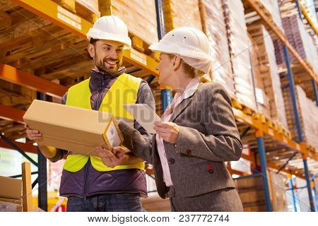 Delivery Managing. Nice Pleasant Woman Talking To The Delivery Man While Controlling The Delivery Se