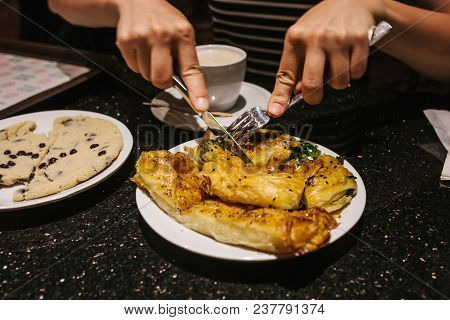 A Person At The Restaurant Who Is Preparing To Eat Traditional Turkish Dish Called Burek. Compositio
