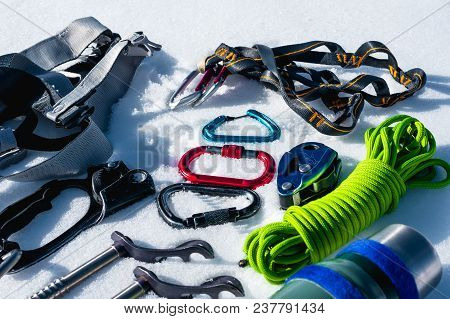 Close-up Of Winter Climbing Equipment On Fresh Snow On A Sunny Day. Carbines With A Rope Gazebo And 