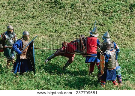 Luh, Russia - August 27, 2016: Reconstruction Of Medieval Battle Of Knights In Armor And Weapons At 