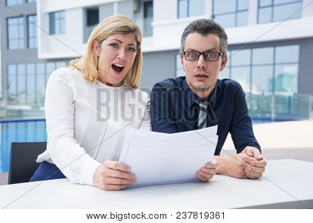 Amazed Business People Shocked With Report Data. Surprised Accountants Viewing Papers And Looking At