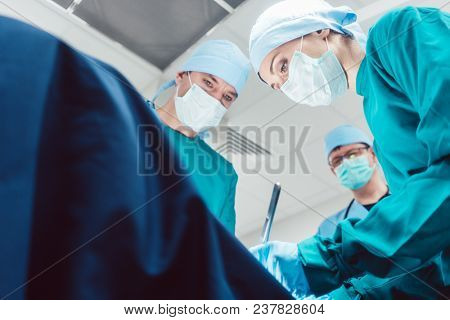 Team of surgeons in operation room during surgery from low angle view