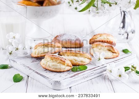 Pasties With Cottage Cheese And Powdered Sugar On A Light Wooden Background. Traditional Russian Pas
