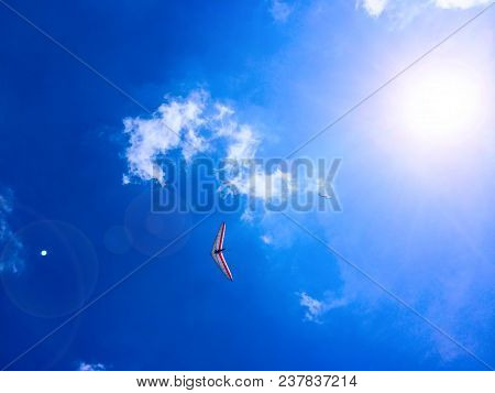 Paraglider And Hang-glider In The Blue Sky With Clouds