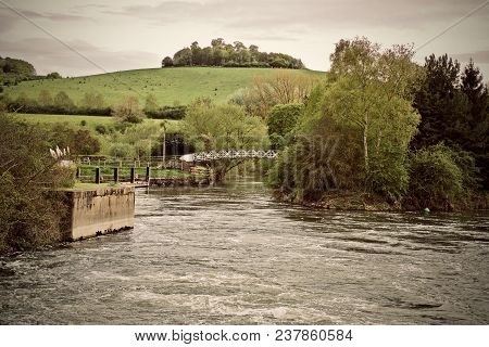 White Bridge On The River Near Green Hill With Tree. England.