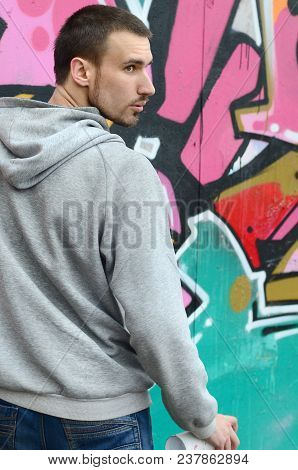 A Young Graffiti Artist Looks Around While Drawing. Vandal Tries To Be Undetected While Drawing The 