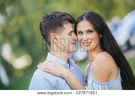 Happy Loving Couple Stay And Hugging At Park Background Lake. Young Cople That Is About To Kiss. Sum