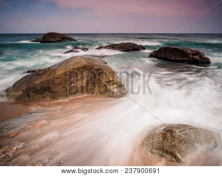 Rocks On A Beach In A Tide Pre-sunset.