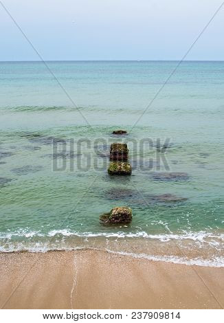 Old Stone Pier In The Green Water In Mallorca, Spain