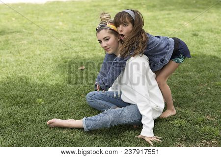 Girl Hugging Behind Her Sister.