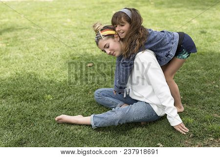 Girl Hugging Behind Her Sister.