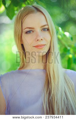 Attractive Modest Young Girl With Blond Dren Hair And Natural Make-up In Purple Dress Outdoors, Tend
