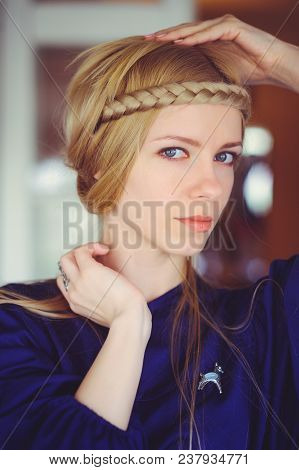 Pretty Blonde Woman With Braided Hair Playing, Hands On Her Head Dressed In A Blue Dress, Beautiful