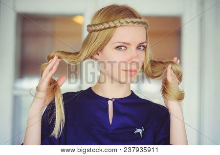 Cute Blonde Woman With Braided Hair Playing, Dressed In A Blue Dress, Beautiful Portrait In The Hous