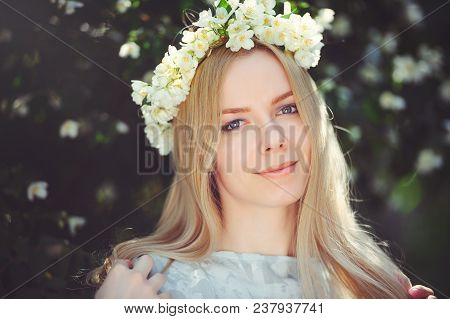 Attractive Modest Young Girl With Blonde With Jasmine Flowers Wreath On Head Long Hair And Natural M