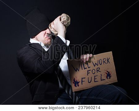 Photo Of A Alchoholic Homeless Business Man Drinking From A Bootle And Sitting With Cardboard Sing.