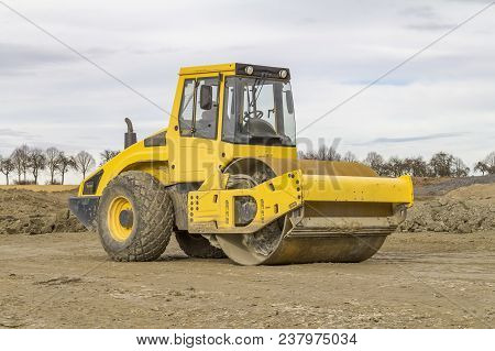 Yellow Road Roller At A Loamy Construction Site