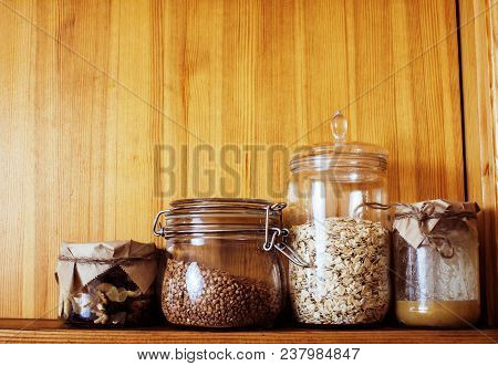 Real Comfort Wooden Kitchen With Breakfast Ingredients Close Up In Glass, Honey, Oatmeal, Milk, Mues