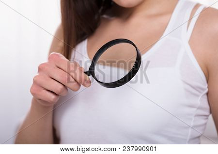 Woman Holding Magnifying Glass Showing Breast Care Concept
