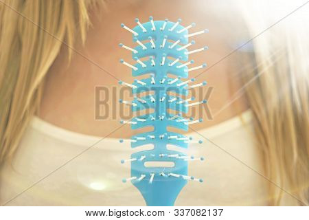 Closeup Blue Comb, Young Girl With Wet Blond Hair On A Blurred Background.