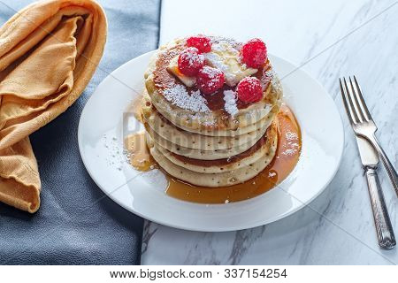 Pancakes With Maple Syrup Powdered Sugar Raspberries And Butter