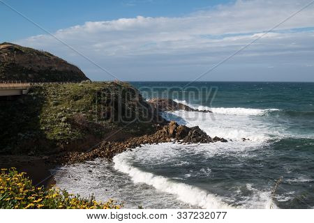 Wild Waves Of The Mediterranean Sea With A White Foam. Sunny Spring Day With White Clouds On The Blu