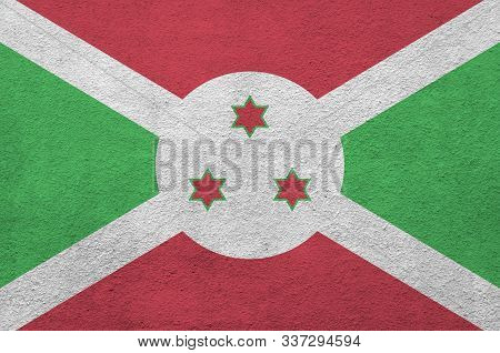 Burundi Flag Depicted In Bright Paint Colors On Old Relief Plastering Wall. Textured Banner On Rough