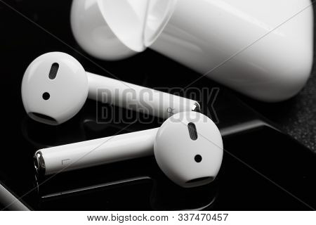 White Apple Airpods Lie On A Dark Black Surface Of Iphone - Image