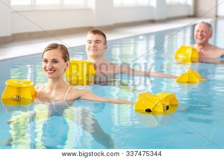 Patients during remobilization in a health center doing aquarobics in the water of a pool