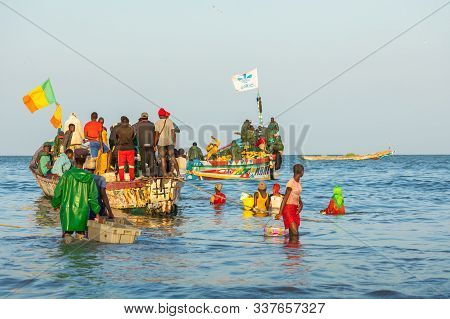 Tanji, The Gambia - November 21, 2019: Scene With Men And Women Carrying Fish From The Boats To The