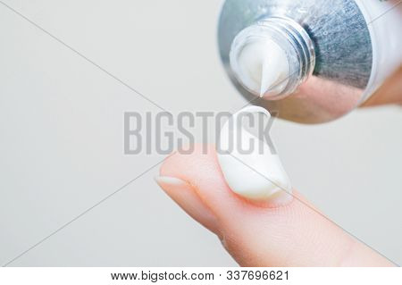 Drop Of Moisturizing Cream On Fingertip. Young Girl Or Adult Woman Wearing Hand Cream. Woman Droppin