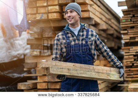Young male worker in timber warehouse 