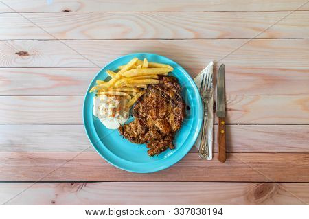 Cajun Chicken Chop With Coleslaw And French Fries On Blue Plate. Western Food With Cutleries On Flat