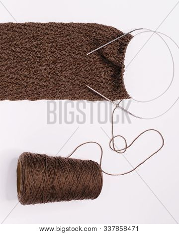 Photo Of Knitted Brown Scarf In Process. Herringbone Pattern. Needles And Bobbin Yarn. Flat Lay, Cop