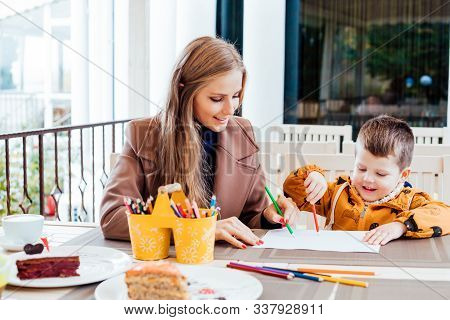 Mother And Son In The Restaurant Painted Pencils Before Eating