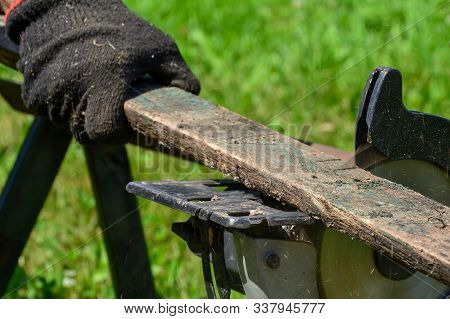 Sawing Old Boards With A Circular Saw. The Process Of Sawing Wood For Processing. Close The Circular