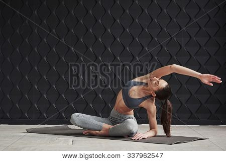 In Yoga Pants. Girl With Good Fitness Body Type Have Exercises In The Spacey Room.