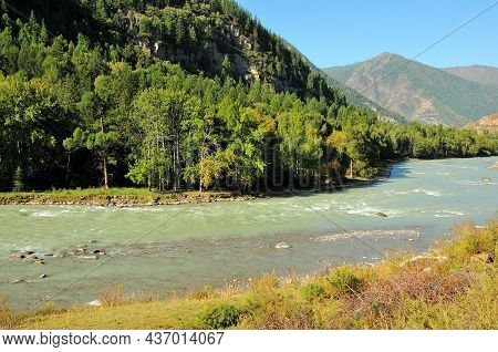 A Beautiful Turquoise River, Flowing In A Stormy Stream Through A Beautiful Valley Surrounded By Mou