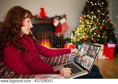 Caucasian woman on christmas laptop video call with diverse group of woman. christmas, festivity and communication technology.