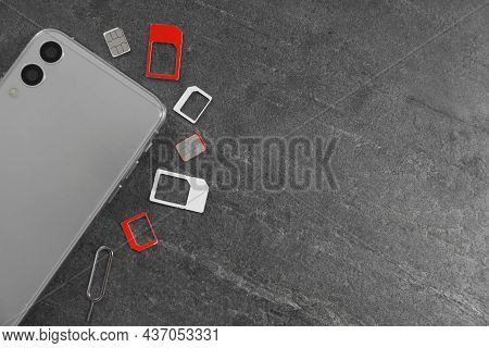 Sim Cards, Mobile Phone And Ejector Tool On Grey Table, Flat Lay. Space For Text