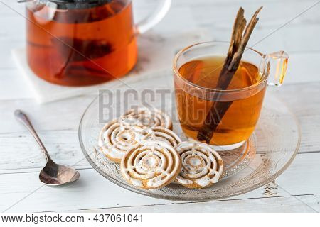 Cinnamon Swirl Cookies On A Glass Plate With A Glass Cup Of Cinnamon Chia Tea.