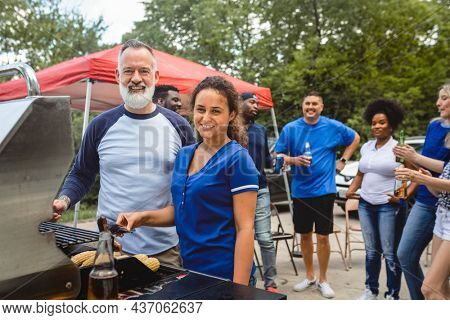Friend grilling burgers at a tailgate party