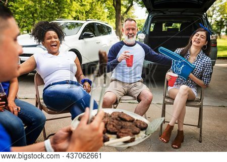 Friends drinking and eating at a tailgate party