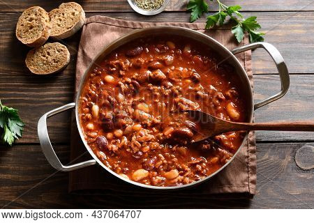 Cowboy Beans With Ground Beef, Jalapeno Pepper And Bacon In Cooking Pan Over Wooden Background. Clos