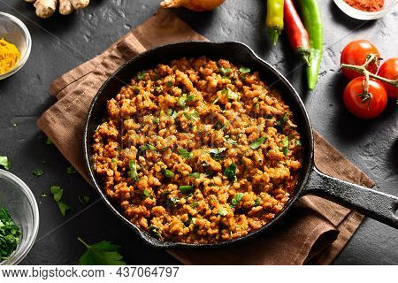 Keema Curry In Frying Pan Over Black Stone Background. Indian And Pakistani Style Dish. Close Up Vie