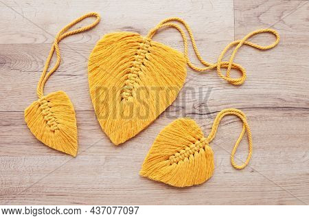 Macrame Leaves In Yellow Color On The Wooden Background. Cotton Rope Decor Macrame To Make Your Home