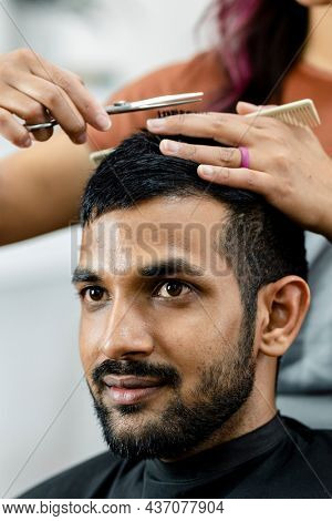 Man getting a haircut from a hair stylist at a barber shop