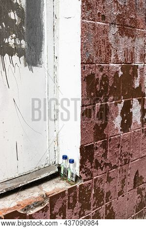 Pair Of Drunk Quarter-litre Bottle On Outer Sill Of Window Of An Old Tilled Shabby House