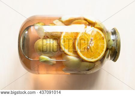 Top View Of Lying 3-liter Glass Jar Of Homemade Compote Made From Sliced Fresh Apples And Oranges On